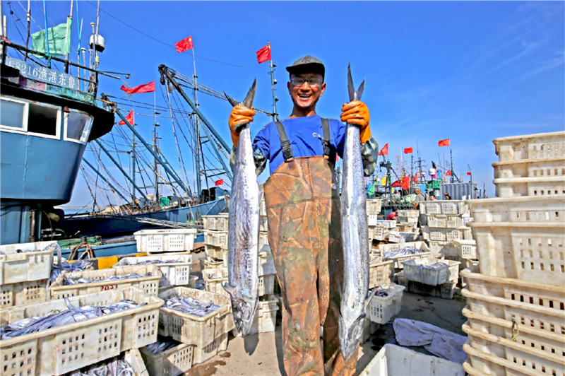 一位漁民正在展示捕獲的大鲅魚。薄林 攝