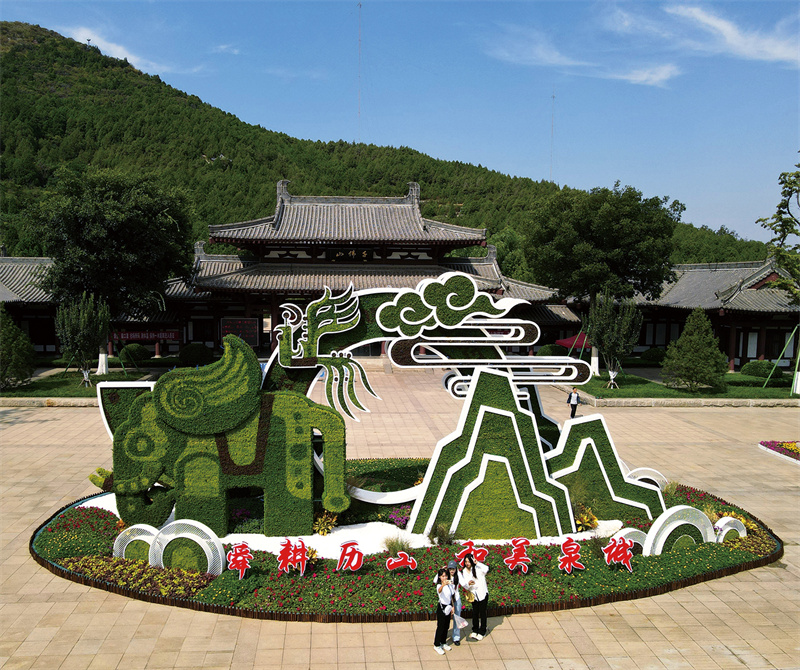 濟(jì)南千佛山公園景區(qū)裝扮一新，喜迎國慶。市民游客在花壇造型前合影留念。馬劍攝