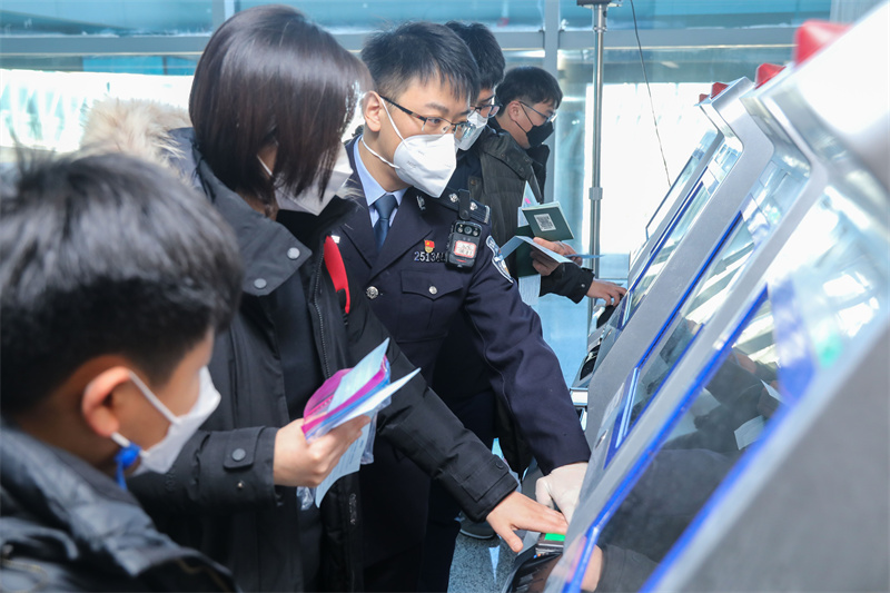 1月9日，山東出入境邊防檢查總站青島機場邊檢站民警引導(dǎo)旅客采集入境通關(guān)信息。解豪攝