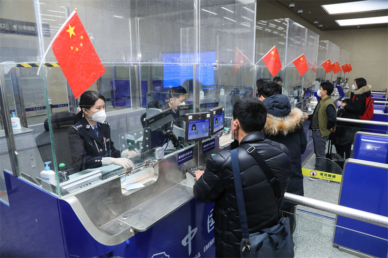 1月9日，山東出入境邊防檢查總站青島機(jī)場(chǎng)邊檢站民警為入境旅客辦理通關(guān)手續(xù)。解豪攝