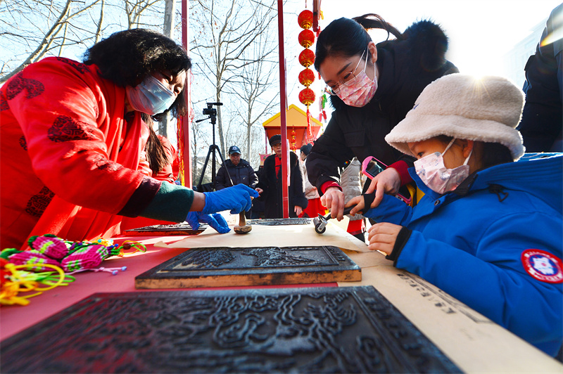 一名小朋友體驗(yàn)紅島街道的非遺傳統(tǒng)木板年畫制作。王海濱攝