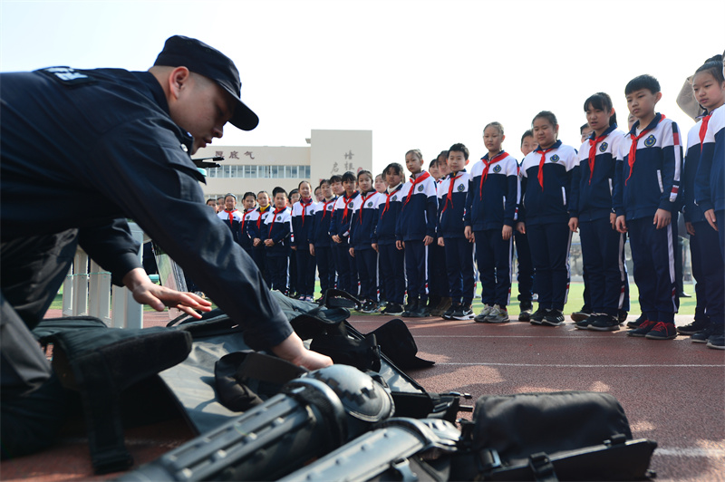 轄區(qū)民警向?qū)W生們介紹警用防護(hù)裝備。王海濱攝