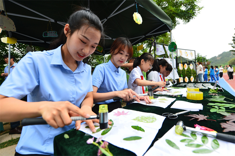 6月17日，在山東省青島市城陽區(qū)夏莊街道丹山森林公園，丹山小學(xué)的師生在制作樹葉拓印畫。王海濱攝