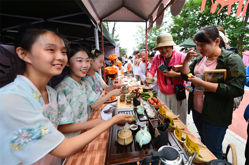 夏莊小學(xué)的學(xué)生體驗煮制當(dāng)?shù)氐木G茶讓與會嘉賓品嘗。王海濱攝