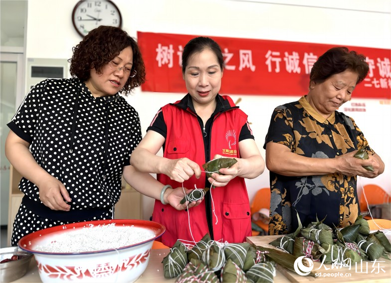 6月21日，濟(jì)南市市中區(qū)二七新村街道建南社區(qū)舉行“鄰里家和美，端午祝安康”活動(dòng)。社區(qū)居民聚在一起包粽子、迎端午。人民網(wǎng) 喬姝攝