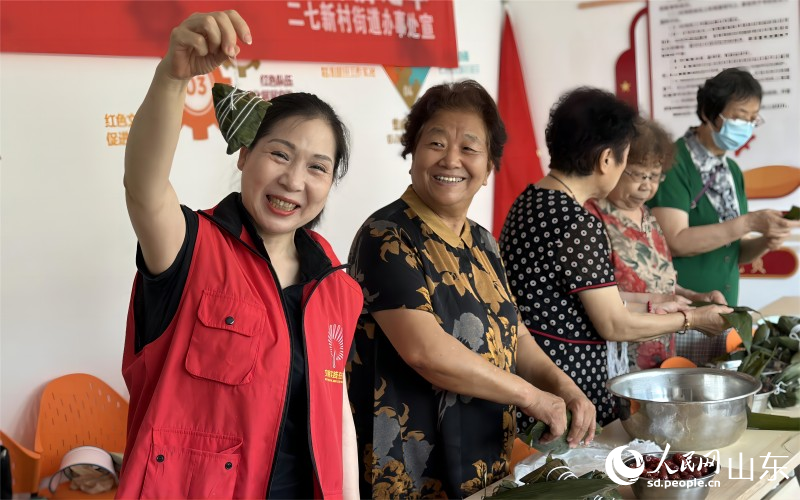 6月21日，濟(jì)南市市中區(qū)二七新村街道建南社區(qū)舉行“鄰里家和美，端午祝安康”活動。社區(qū)居民聚在一起包粽子、迎端午。人民網(wǎng) 喬姝攝