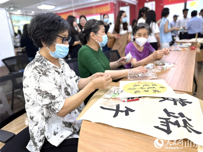 6月20日，濟(jì)南市市中區(qū)舜耕街道舜雅社區(qū)聯(lián)合濟(jì)南職業(yè)學(xué)院開(kāi)展“中華優(yōu)秀傳統(tǒng)文化體驗(yàn)進(jìn)社區(qū)”活動(dòng)，社區(qū)居民和同學(xué)們一起編織五彩繩，迎接端午，祈福納吉，驅(qū)災(zāi)避邪。人民網(wǎng) 喬姝攝