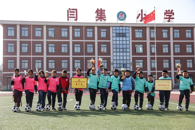 12月6日，學生們手持獲得的榮譽在鐵營鎮(zhèn)閆集小學足球場開心地合影。