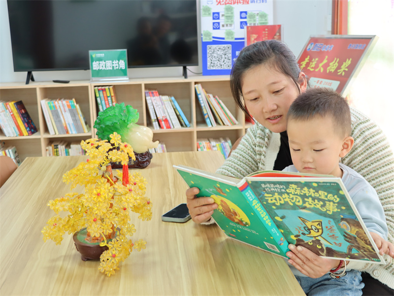 圖為村民帶著孩子在雪穎超市的圖書(shū)角讀書(shū)